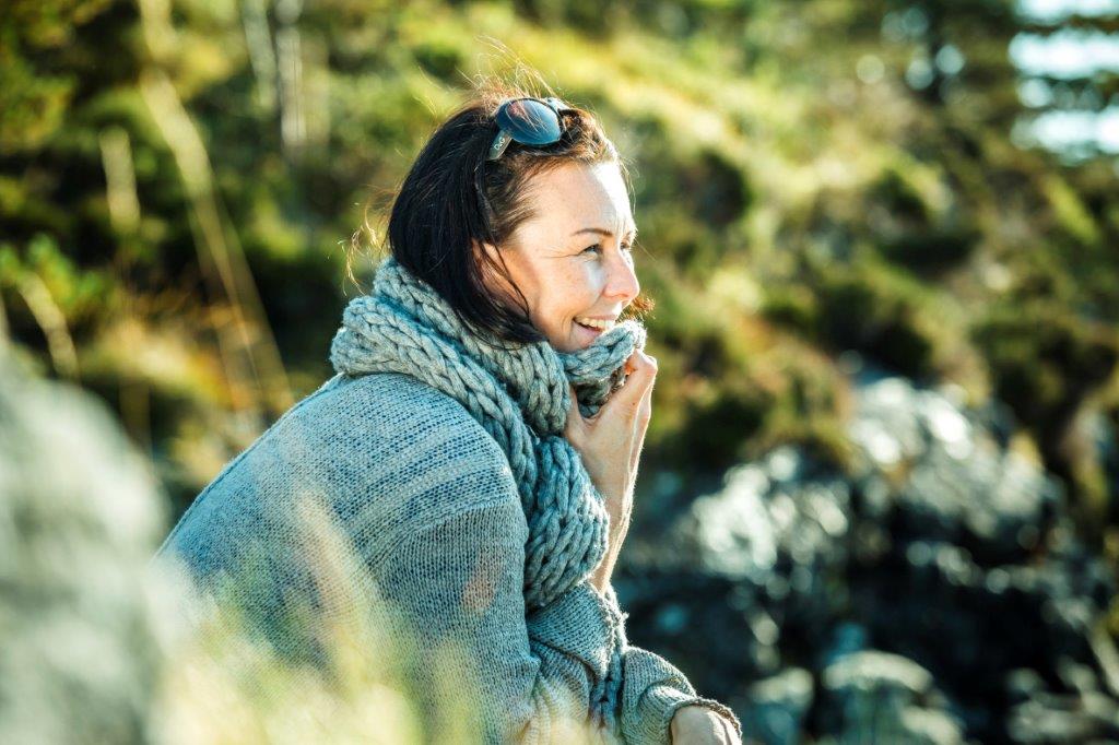 Kvinde smiler i naturen