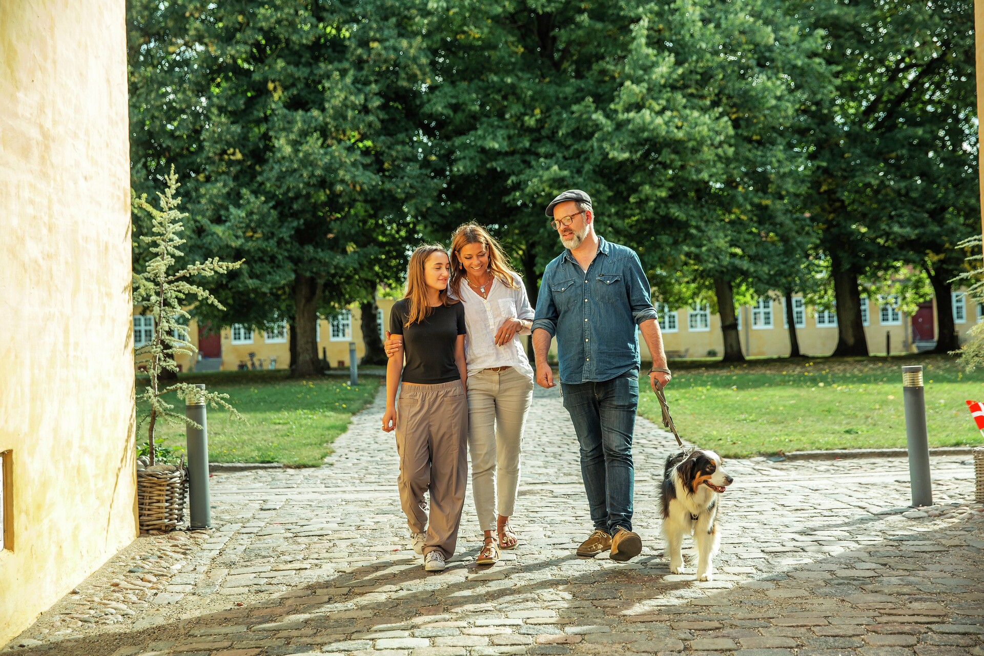 Familie går tur med hund i park