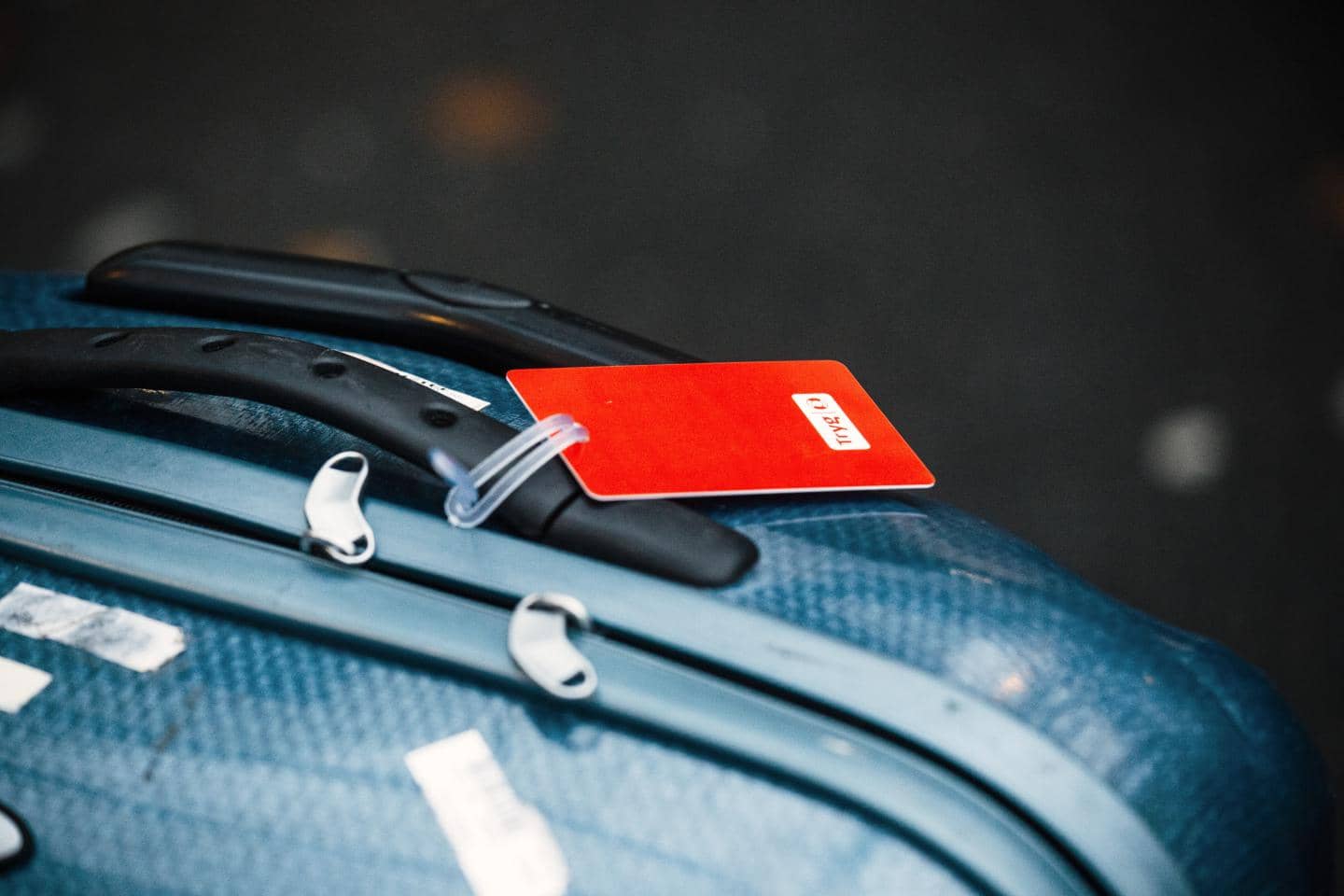 Nærbillede af kuffert med rødt tag fra Tryg